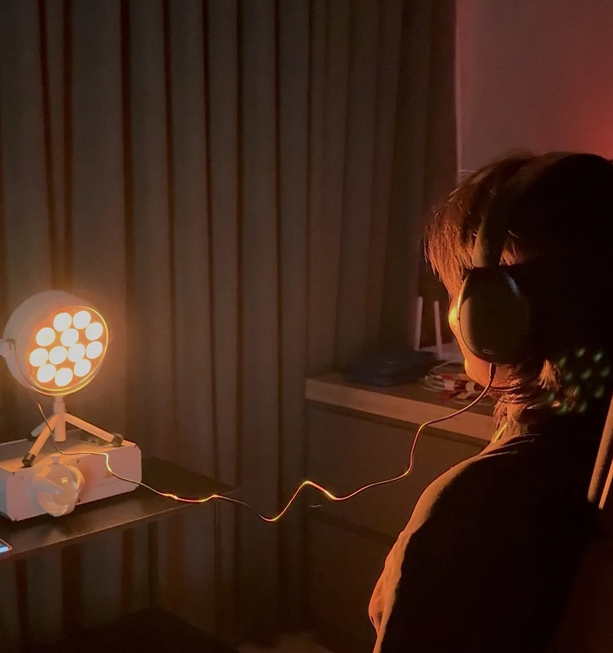 Participant wearing headphones during a guided orange AuraSync light and sound session