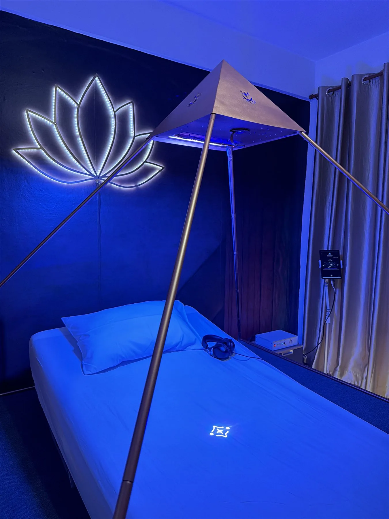 Luminara session bed, control tablet, headphones, and illuminated pyramid