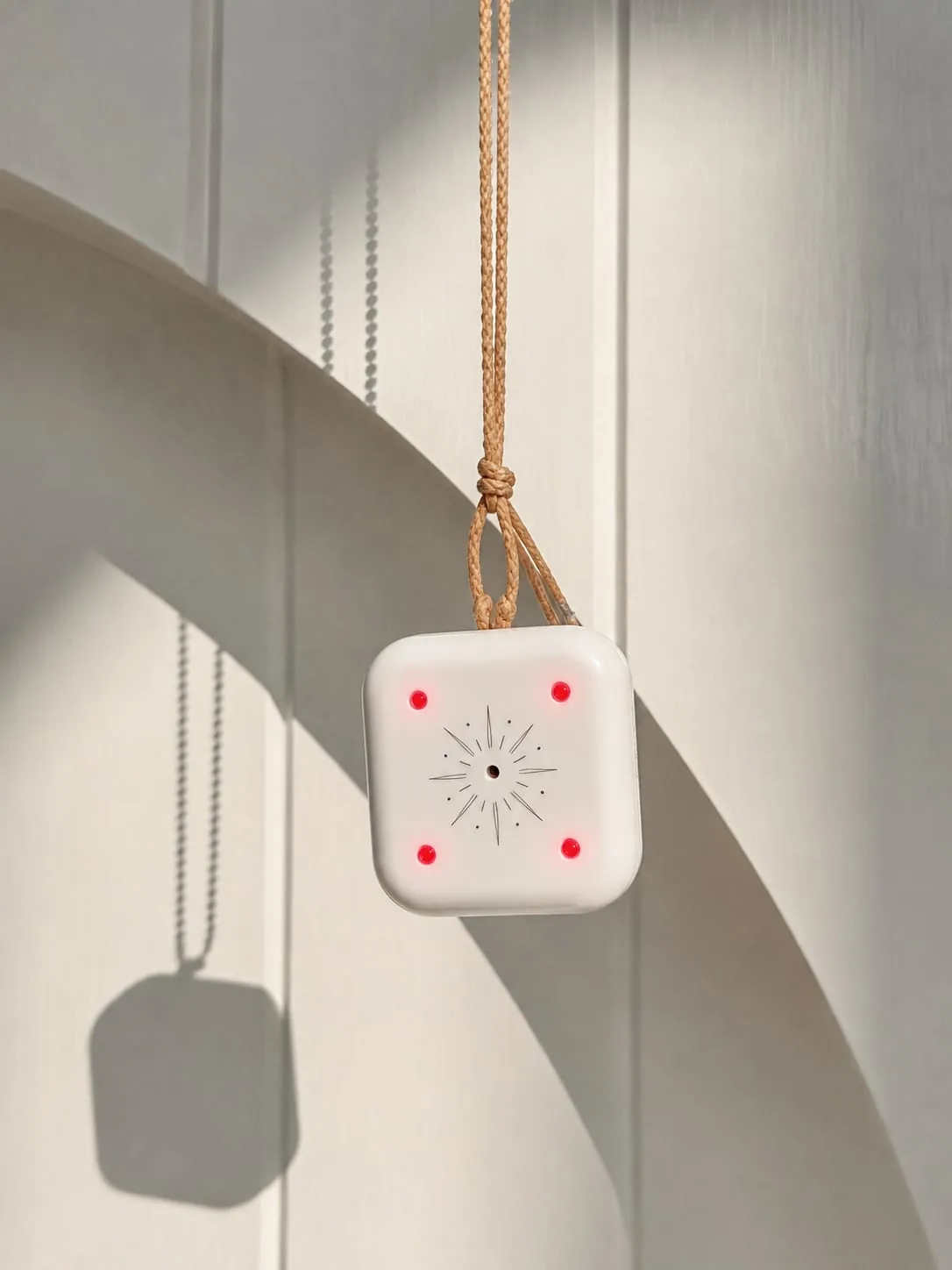 Mandala Breeze pendant hanging in soft architectural light with four red LEDs illuminated