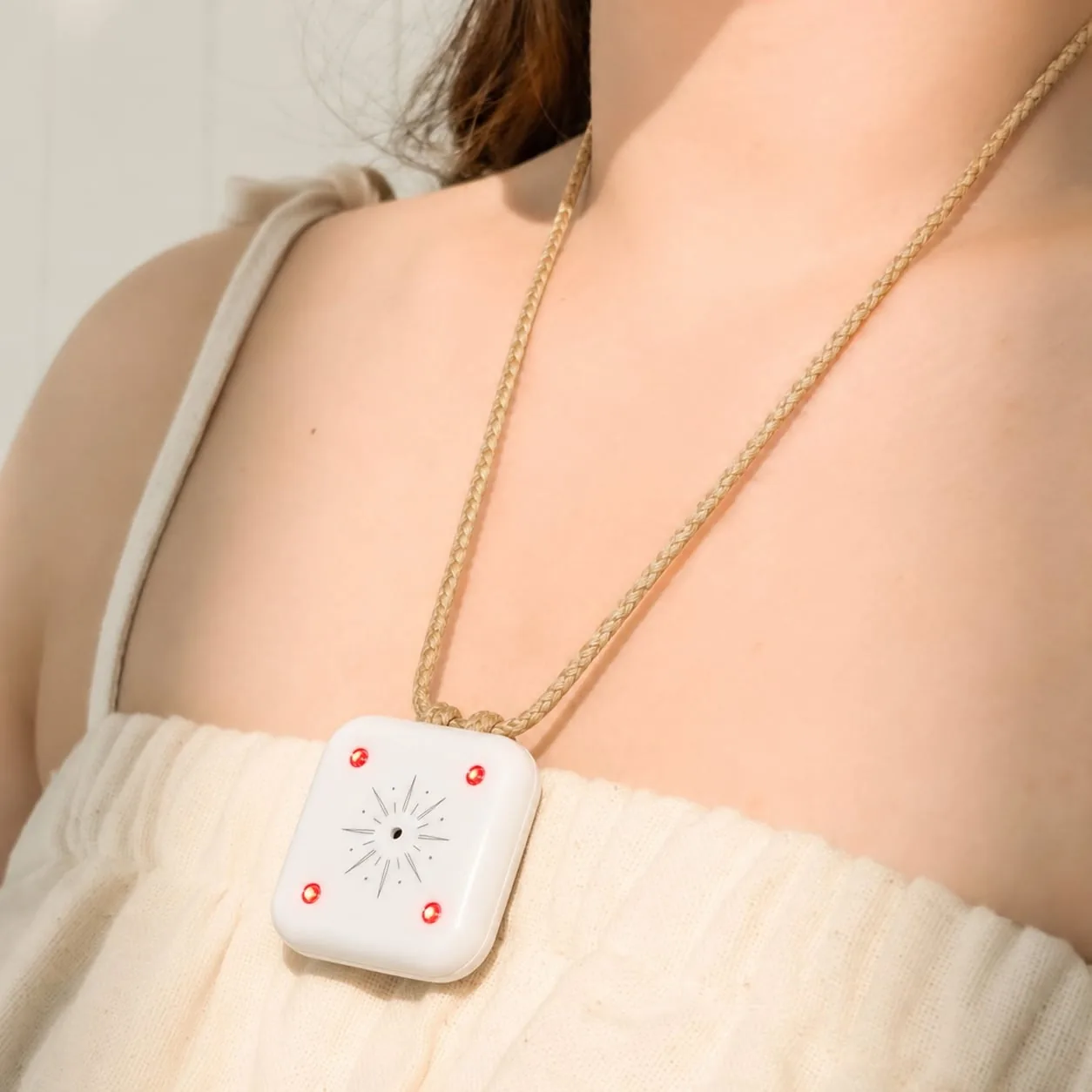 Mandala Breeze worn as a pendant against a soft cream top in natural light