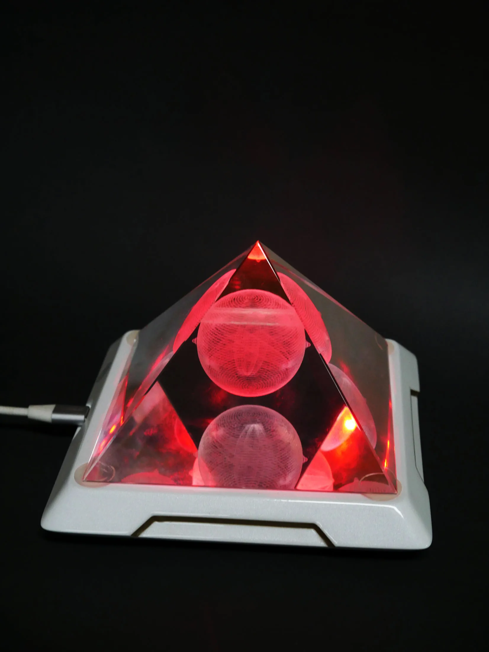 Mandala Resonator pyramid glowing with a vivid red harmonizing light program