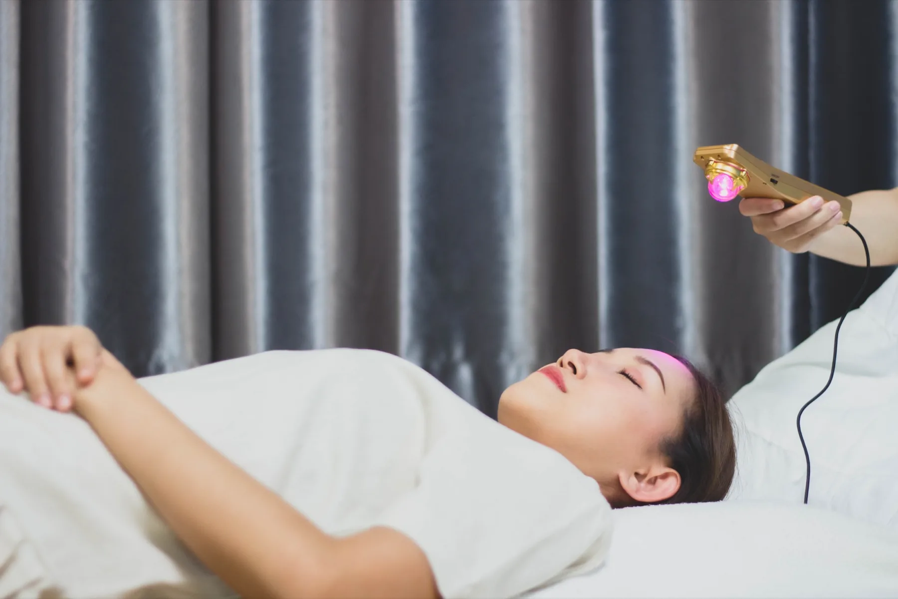 Practitioner holding the Mandala Wand above a relaxed participant while preserving the participant's complete visible head and face