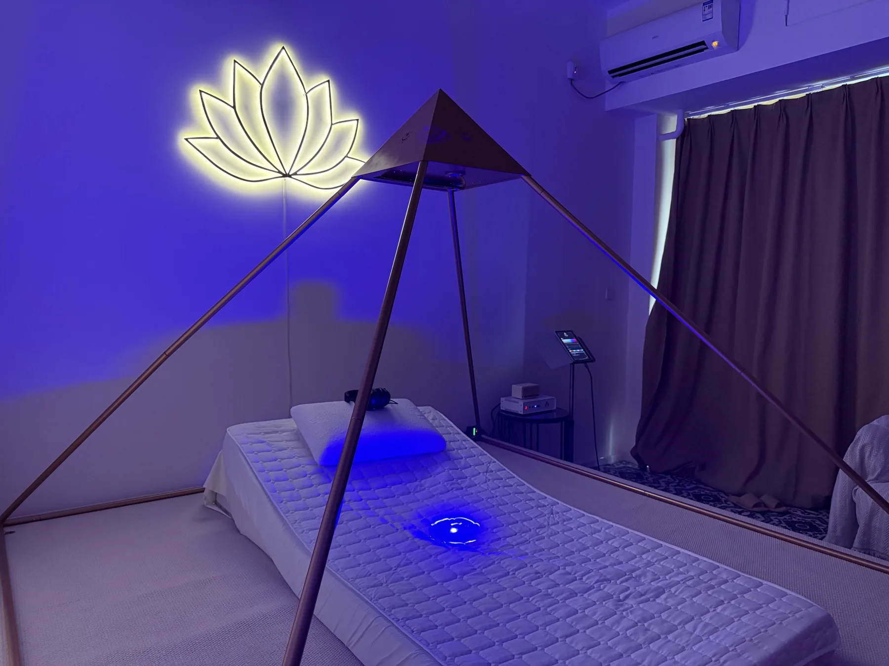 成都の YUN SHU SHENG SHI にある、青い光と蓮の壁面照明を備えた Luminara Pyramid ウェルネスルーム